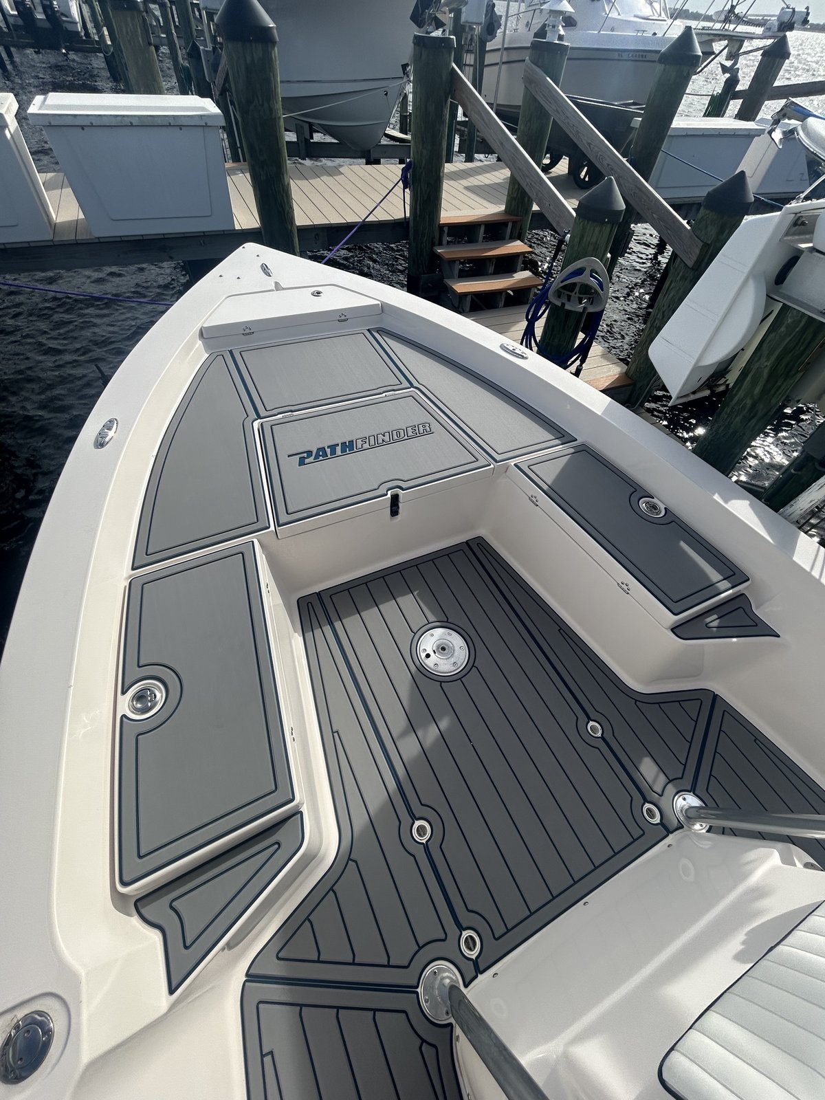 Bow deck on a Pathfinder center console, gray planking with navy seams and inlaid logo