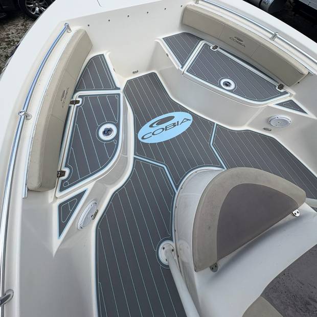 Bow seating and casting deck in gray planking with an inlaid Cobia logo