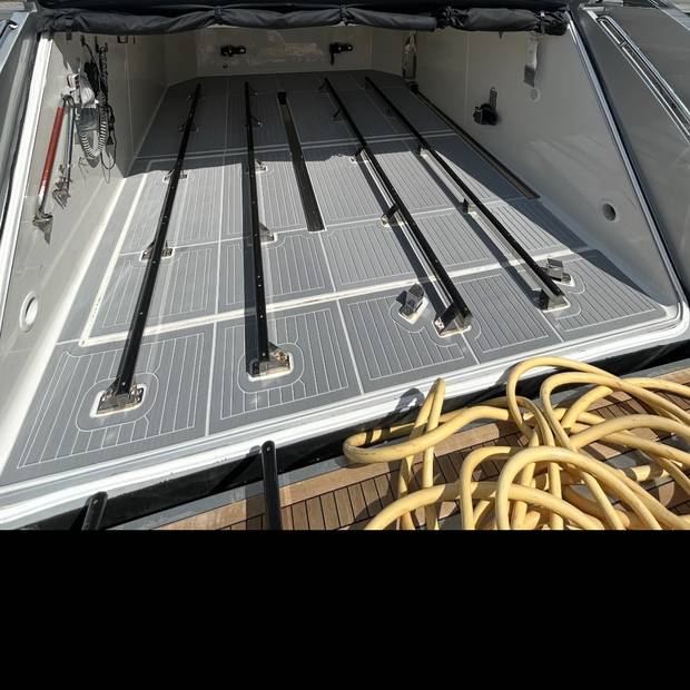 Decked tender garage on a motor yacht, gray planking with white seams
